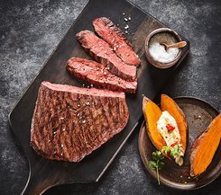 Gegrilltes Steak mit Süßkartoffeln und Meersalz Gegrilltes Steak mit Süßkartoffeln und Meersalz auf einem Holzbrett