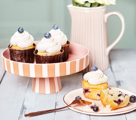 Blaubeer-Cupcakes mit Sahnehaube Blaubeer-Cupcakes mit Sahnehaube auf einer rosa-weißen Tortenplatte