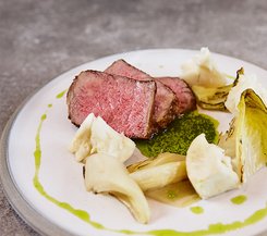 Rinderfilet mit gegrilltem Gemüse und grüner Sauce Ein Teller mit zartem Rinderfilet, serviert mit gegrilltem Gemüse und einer grünen Sauce.