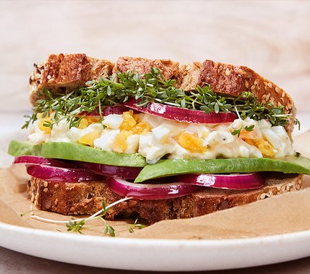 Sportlerbrot-Sandwich mit Eiersalat und Avocado Ein Sandwich aus Sportlerbrot, gefüllt mit Eiersalat, Avocado, roten Zwiebeln und frischer Kresse.