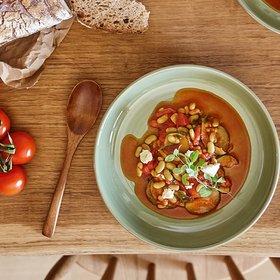 Gemüseeintopf mit Tomaten und Brot Gemüseeintopf mit Tomaten und Brot auf einem Holztisch