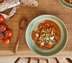 Gemüseeintopf mit Tomaten und Brot Gemüseeintopf mit Tomaten und Brot auf einem Holztisch