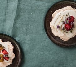 Pavlova mit Birnen und Erdbeeren Pavlova mit Birnen und Erdbeeren auf einem dunklen Teller