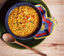 Linsencurry Linsencurry in einer blauen Schale mit einem Holzlöffel