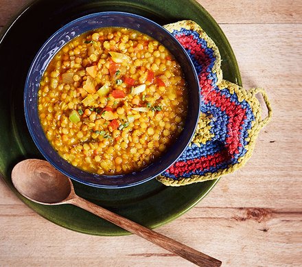 Linsencurry Linsencurry in einer blauen Schale mit einem Holzlöffel