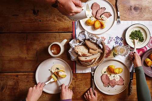 Gedeckter Tisch mit Tafelspitz und Kartoffeln auf einer Alpe.